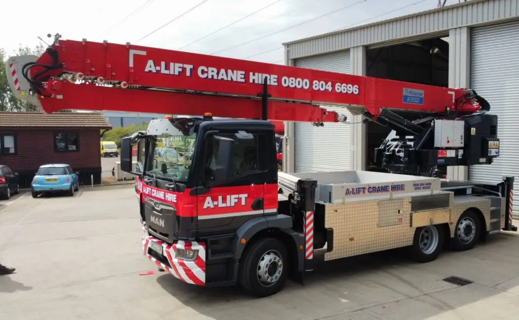 A-Lift Crane Hire truck-mounted crane parked outside a warehouse