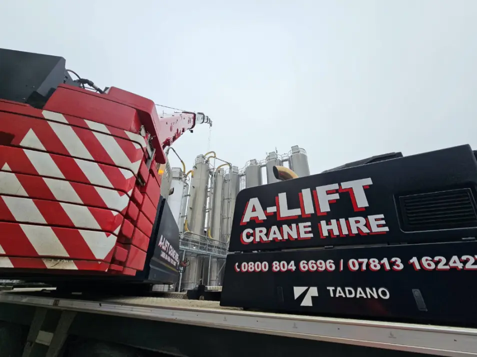 A-Lift Crane Hire Tadano crane with red counterweights beside industrial silos