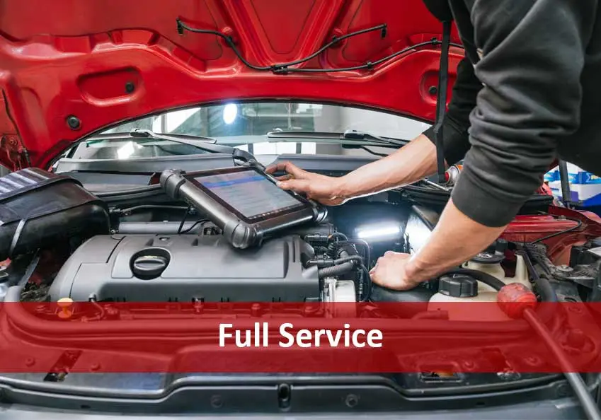Technician using a tablet on a car engine under an open red hood, with Full Service text