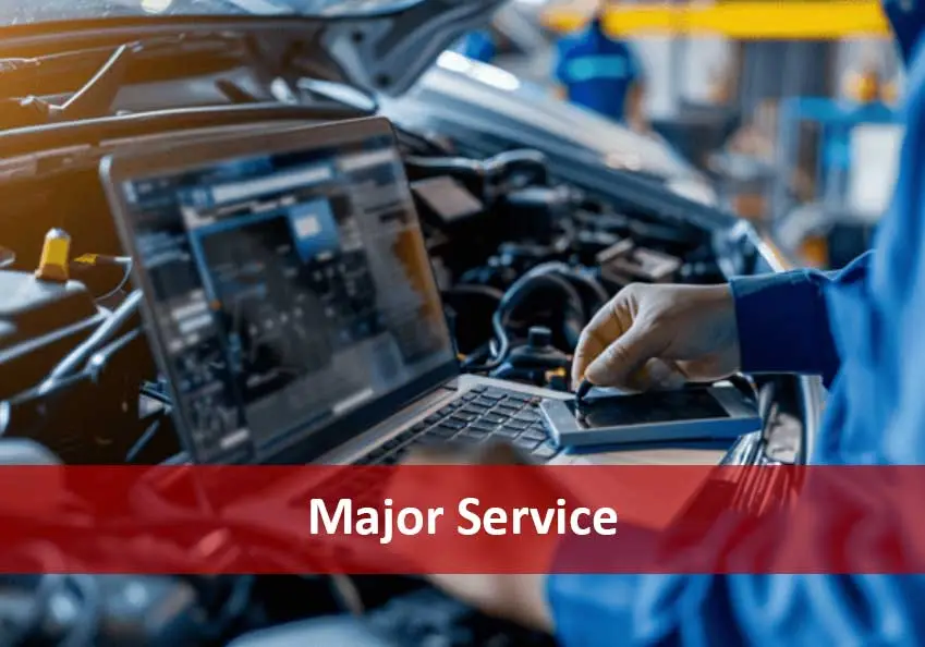 Technician using a laptop beside an open engine bay, with a red banner reading Major Service